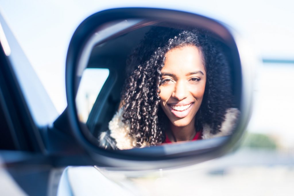 Young black woman sitting in the car smilling