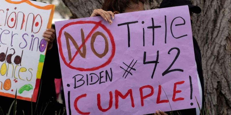 98378300_FILE-PHOTO-A-woman-holds-a-sign-that-reads-No-Title-42-Biden-Cumple-at-a-migrant-led-prot