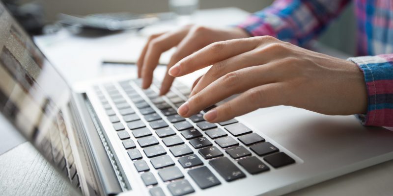 Cropped view of person hands typing on laptop computer
