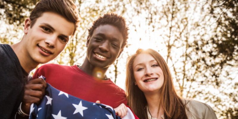 Teenagers with USA flag outdoor.